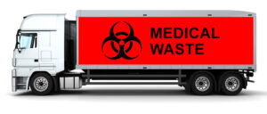 White truck with red cargo area labeled "MEDICAL WASTE" and a biohazard symbol on the side.