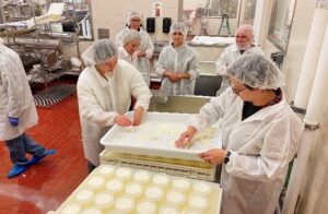 People wearing protective clothing preparing food in a commercial kitchen